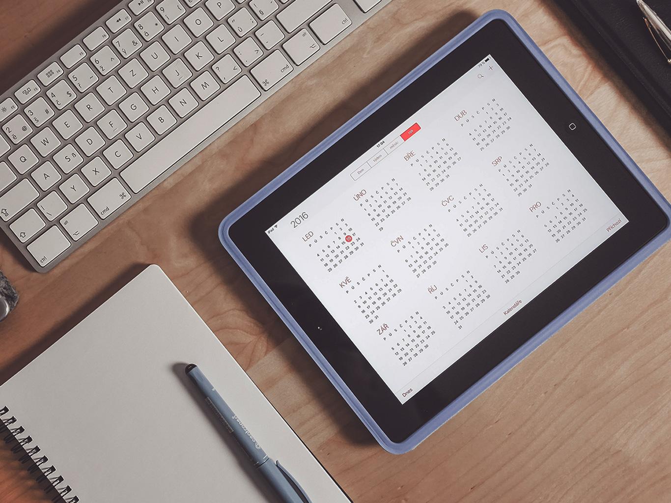 Calendario digital, tableta y teclado sobre mesa